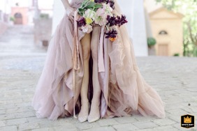 Detail shot of the bride’s bouquet, shoes, and dress at Palazzo del Poggiano in Rimini, Italy.